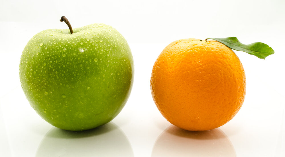 A green apple next to an orange, which invites comparisons and contrasts 