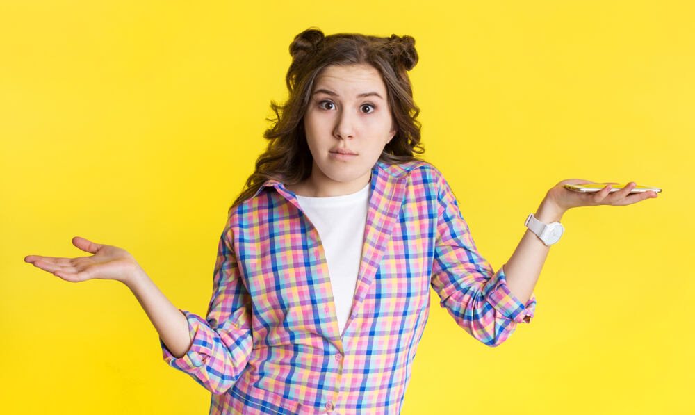 A college student holds up her two hands as if comparing and contrasting two ideas